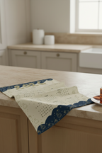 Kitchen counter with2026 tea towel calendar and an espresso cup on a saucer.