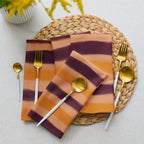 Stylish table setting with striped napkins, gold cutlery on a woven placemat ,luxury home décor by Design by Lola.